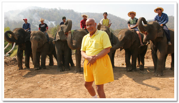 Sri Chinmoy stands before the elephants he has just lifted